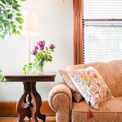 Couch with side table, lamp and floral cushions