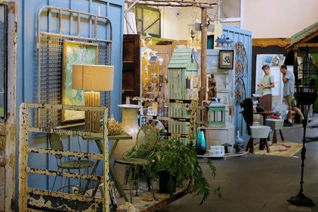 Antiques scattered on table and floor in shop.